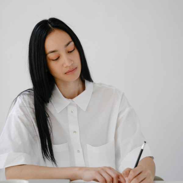 woman seated at a table writing notes