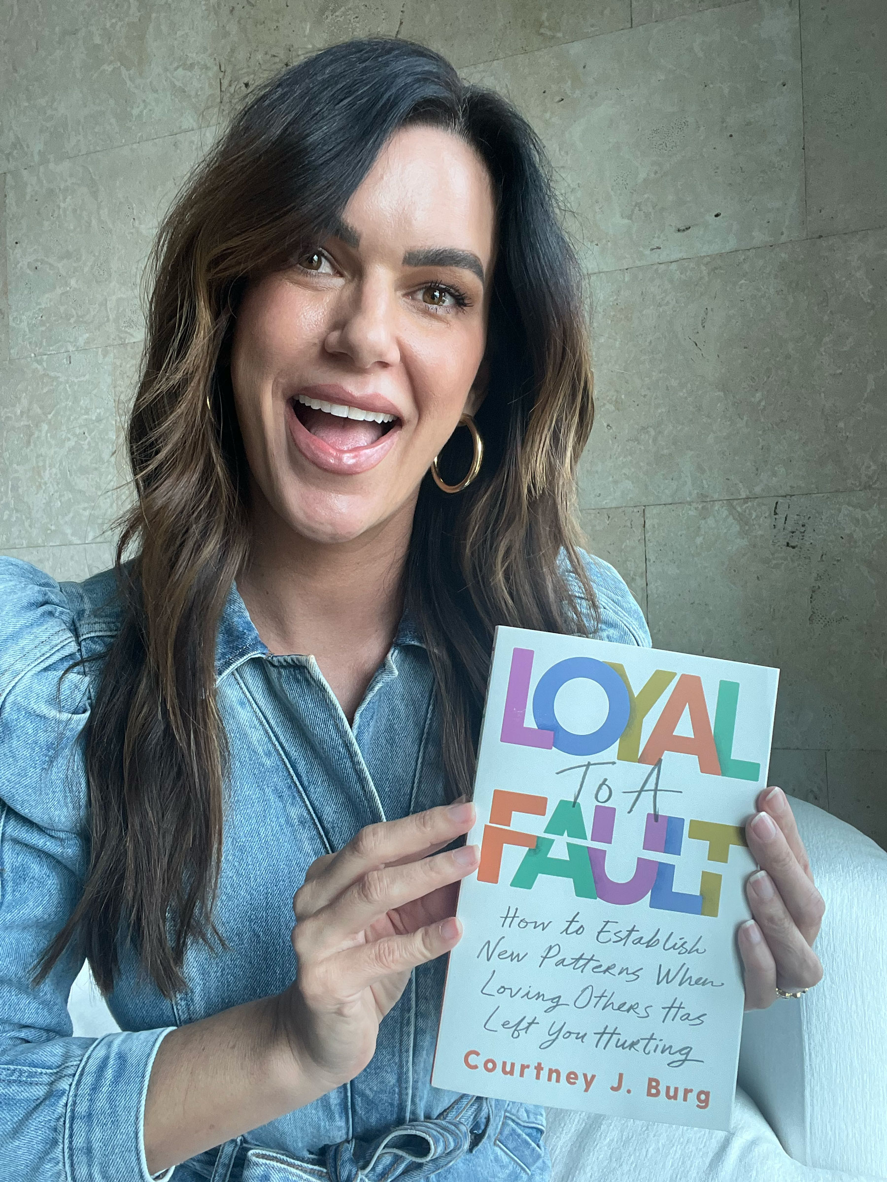 Courtney J. Burg holding a copy of her new book, Loyal to a Fault.